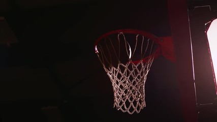 A basketball player dunks the ball, dark lighting, slow motion, view from below - Powered by Adobe