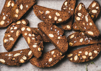 Close-up of dark chocolate and sea salt Biscotti with almonds on baking paper, top view, horizontal composition