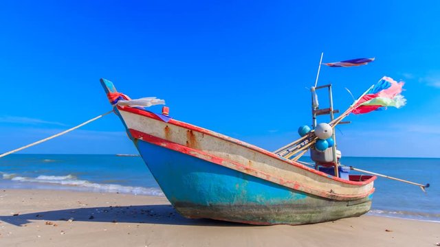 the alone fishing boat on the beach with blue sky in Thailand ocean