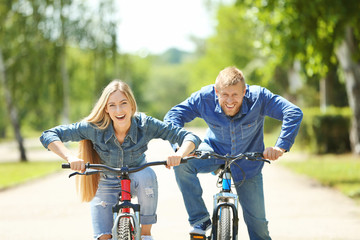 Happy couple riding bicycles in the park