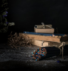 watercolor pencils on the old wooden table. dark background, vintage
