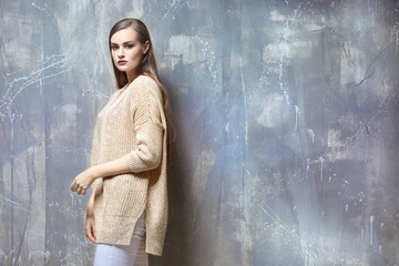 Portrait of young beautiful woman on grey background