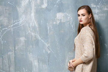 Portrait of young beautiful woman on grey background