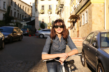 Fototapeta premium Pretty young woman with bicycle outdoors