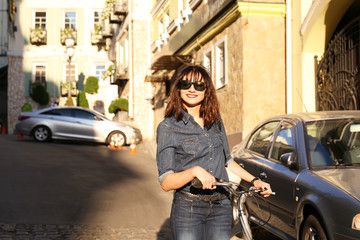 Fototapeta na wymiar Pretty young woman with bicycle outdoors