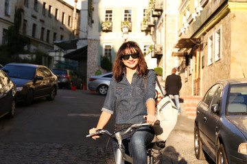 Fototapeta na wymiar Pretty young woman with bicycle outdoors