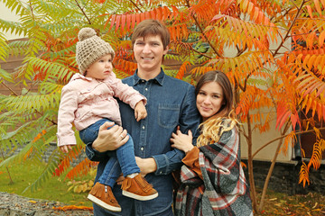 Happy young family in beautiful autumn park