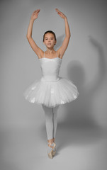 Fototapeta na wymiar Young beautiful ballerina dancing on light background