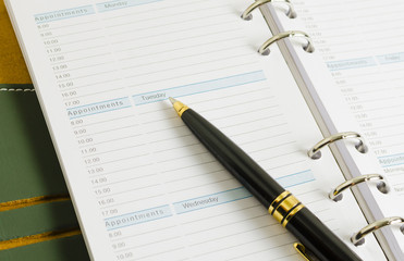 close up shot of daily notebook with pen focus on appointments wording business concept