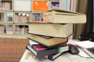 The old books on the table with bookshelf background in the library. Selective focus.