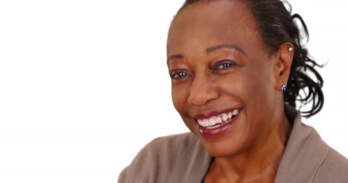 Close-up of a laughing elderly African American woman on a white background. An older black businesswoman happily posing for a portrait on a white backdrop with copy space