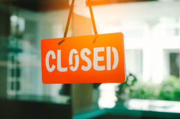 Closed sign hang on mirror door front of office room.