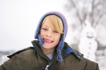 Happy Child Outside playing in the Snow after Building Snowman