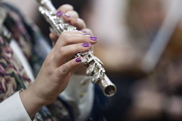 Hands of a woman playing the flute closeup 