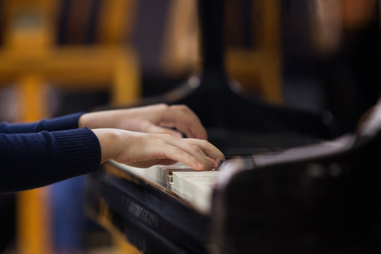 Hands of a child playing the piano closeup 