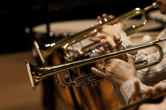 Hands of man playing the trumpet in the orchestra