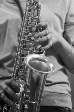 Hands girl playing the saxophone in black and white
