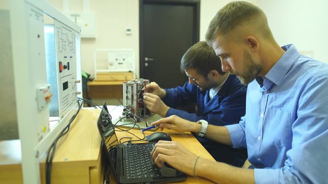 Young engineers working in the laboratory and using a computer