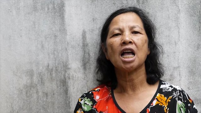 Close up old Thai woman portrait wearing false teeth