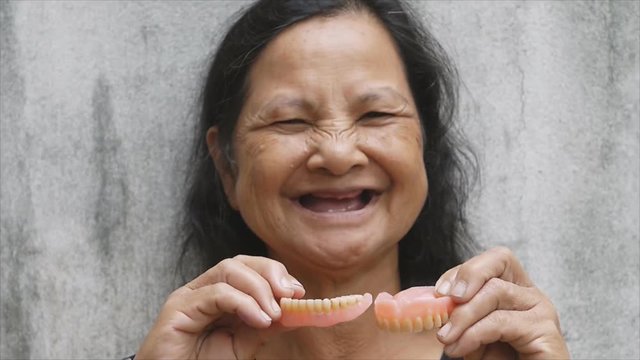 Close up old Thai woman portrait wearing false teeth