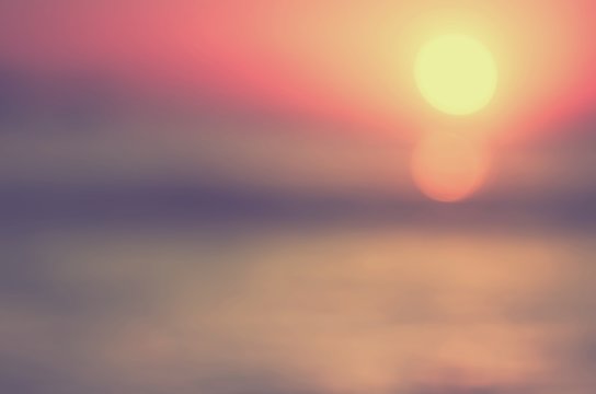 Blur tropical sunset beach with bokeh sun light wave abstract background.