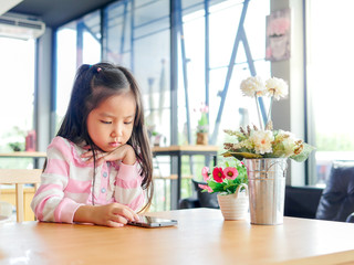 Portrait of Asia pretty little girl play mobile phone