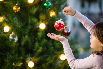 Little girl decorating Christmas Tree