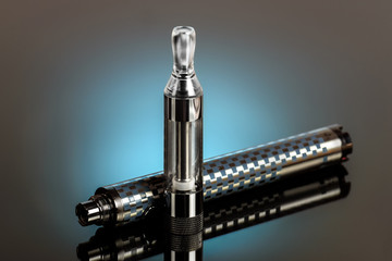 Vape, electronic cigarette exploded next to a conventional cigarette on a dark background with a gradient.