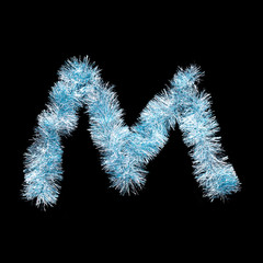 Festive alphabet made of blue tinsel. Letter M on black background. Isolated