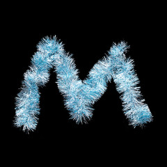 Fototapeta premium Festive alphabet made of blue tinsel. Letter M on black background. Isolated