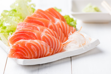 salmon sashimi on white dish and wood background - obrazy, fototapety, plakaty