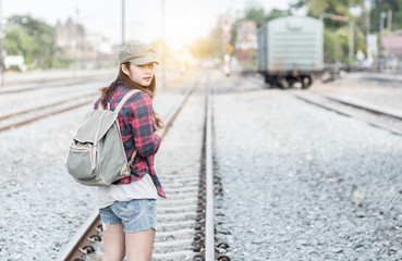 Hipster young girl waiting train on railway background.