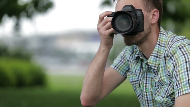 Young Man Taking Pictures At A Professional Digital Slr Camera