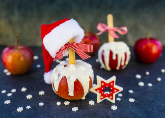 Christmas red delicious apples in white chocolate and Christmas decoration on dark background. 