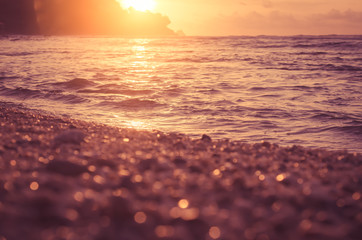 Tropical sunset beach with bokeh sun light sand abstract background.