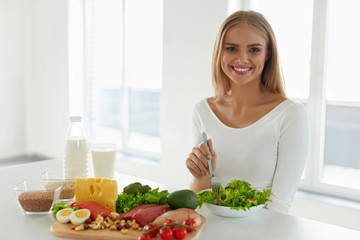 Healthy Nutrition. Beautiful Woman Eating Salad, Foods On Table