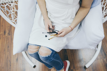 woman with cosmetic eyebrow beauty tools in hands, top view