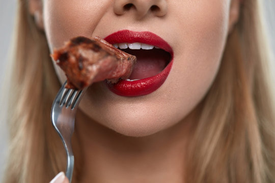 Eating Meat. Closeup Of Sexy Woman's Mouth Biting Tasty Meat
