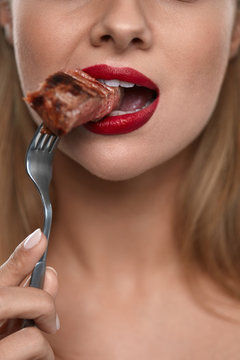 Woman Eating Food. Closeup Of Girl's Face Biting Meat Steak