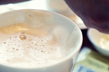 Coffee cup with milky white foam.