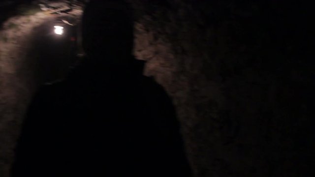 Girl walks through dungeon with flashlight