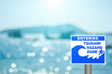 Tsunami sign on blur tropical beach with bokeh sun light wave abstract background.