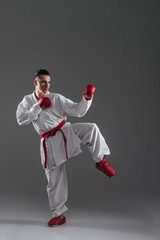 Sportsman practice in karate isolated over grey background