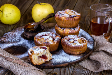 Apple muffins with bowl of honey on wood background