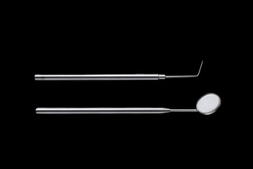 Dental mirror and dental sonde. Image isolated on black background