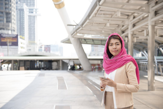 Beautiful Modern Arab Businesswoman wear hijab  Using Mobile Phone in the big city.