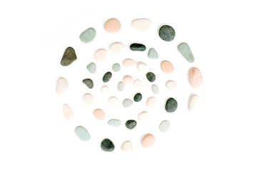 Creative spiral arrangement of colored stones. Mint, pink, beige and grey stones on white. Flat...