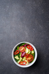 Fototapeta na wymiar Vegetable salad on dark stone table
