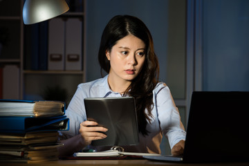 asian business woman use digital tablet working overtime