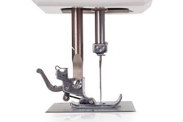 Close up macro detail of the needle, plate, foot and transporter of an electric sewing machine